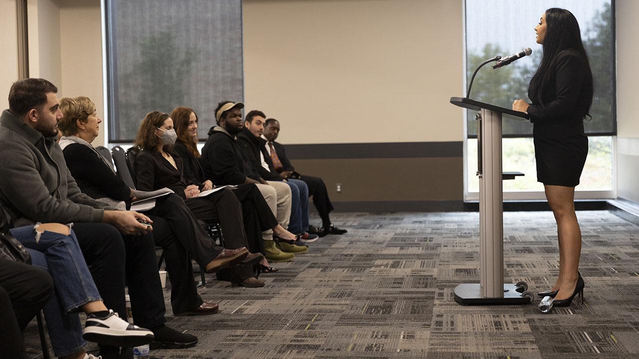 Mena Hannakachl speaks in front of an audience.